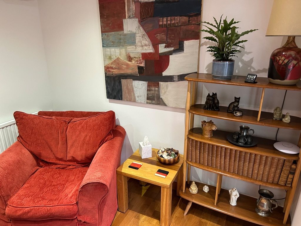 The counselling room: an armchair, side table and bookcase